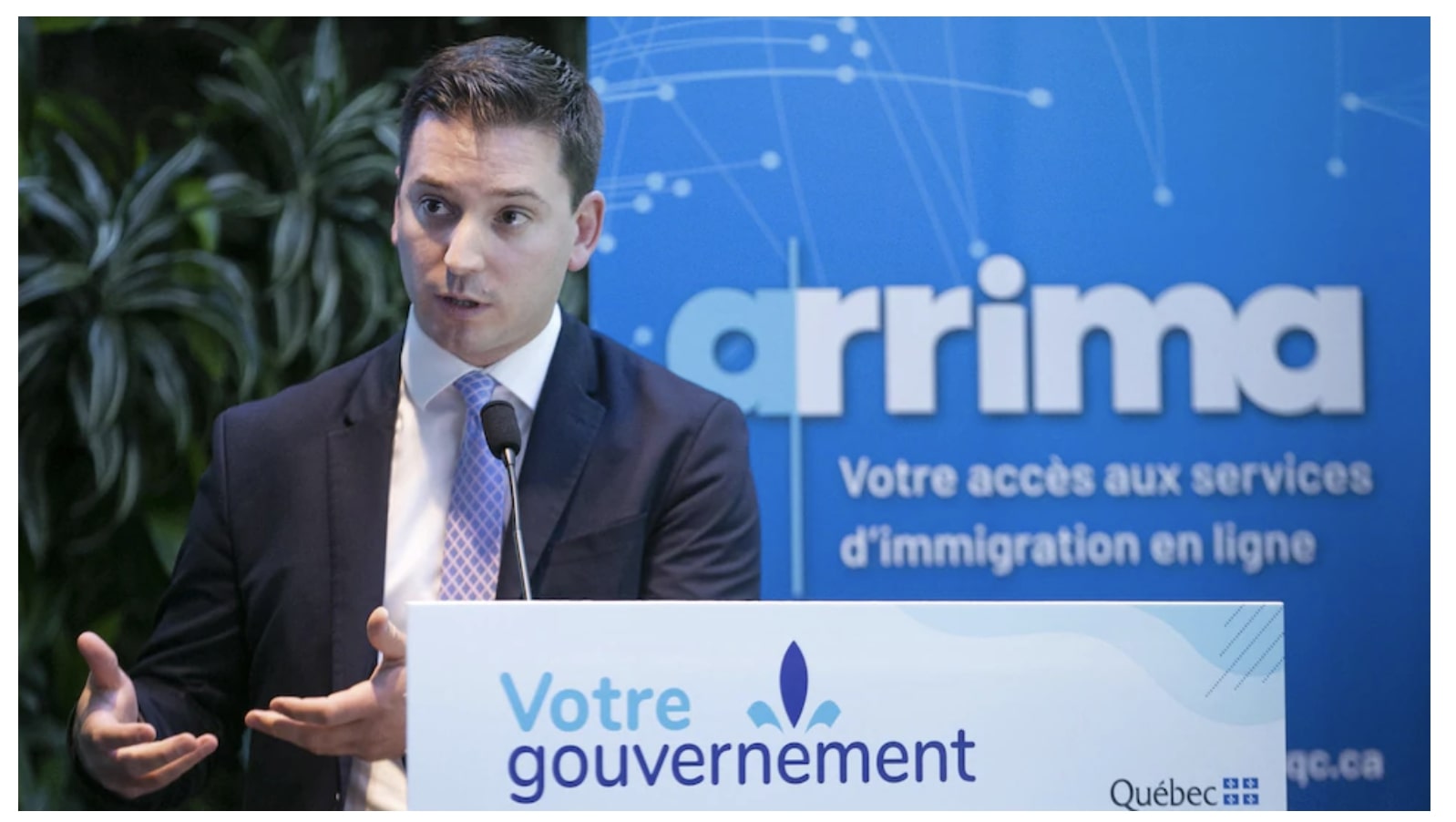 Le ministre de l'immigration devant une affiche d'Arrima